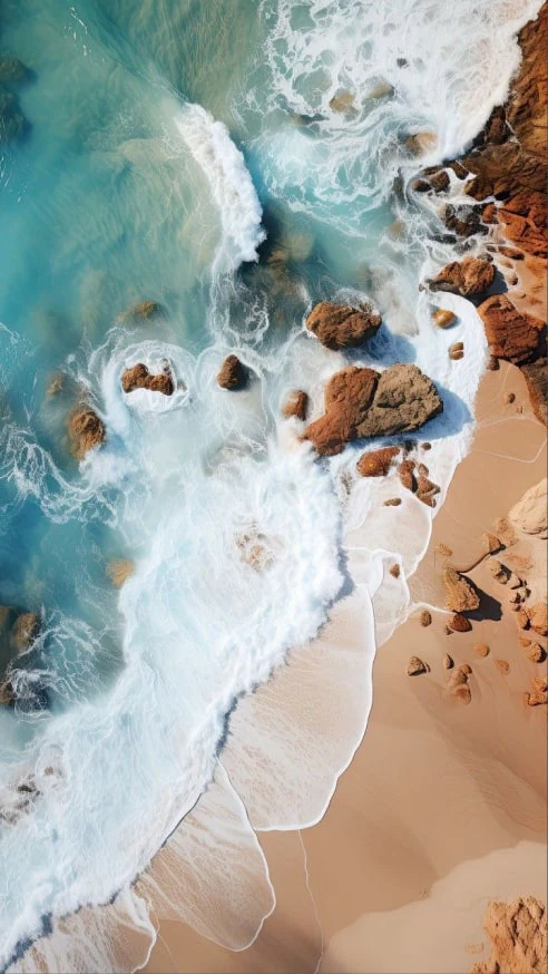 Turquoise tide over sand from above
