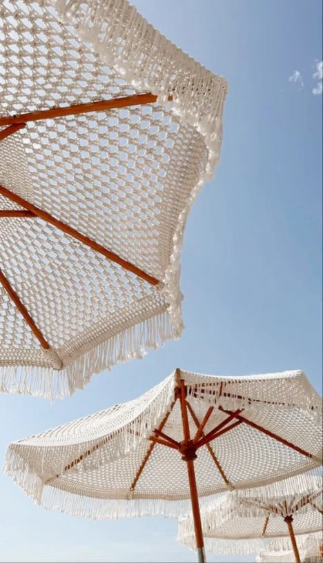 Fringed beach umbrellas against a blue sky
